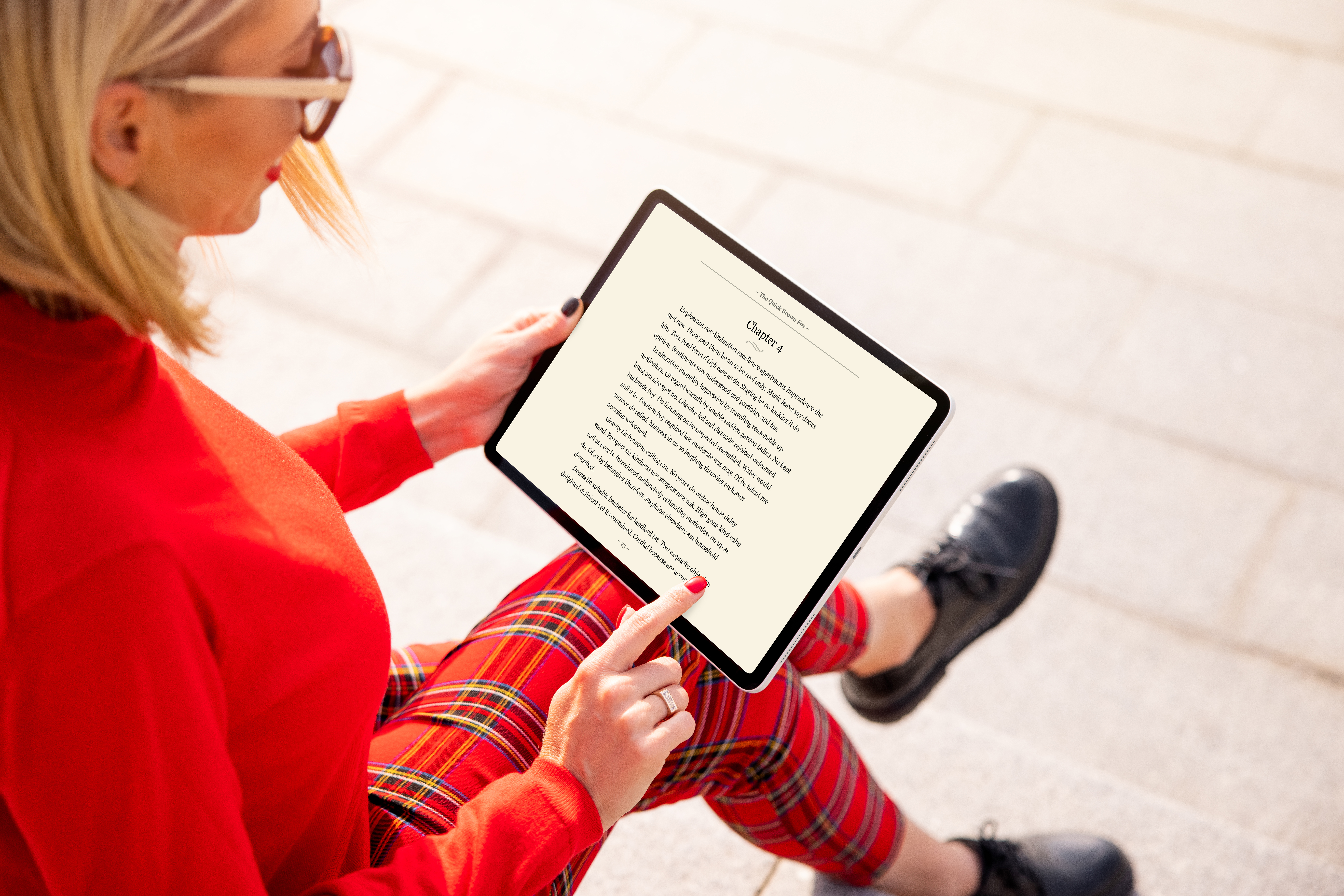 Woman reading a book on tablet. Text on the screen is completely made up.