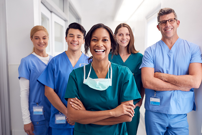 Smiling healthcare workers in scrubs looking at camera