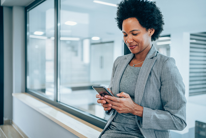 Professional woman inside office reading her mobile phone