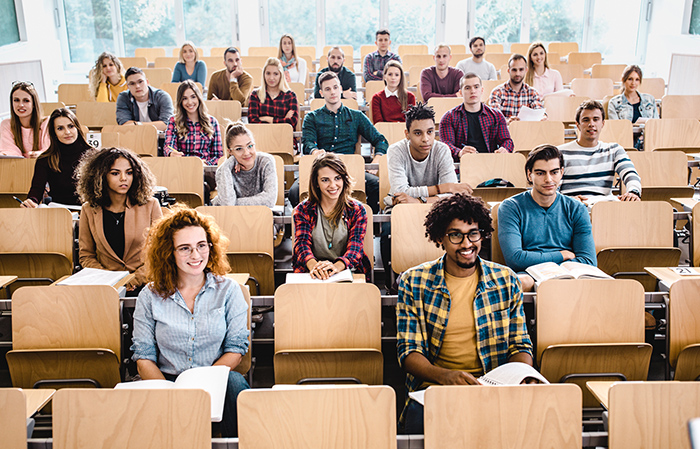 Group of students sitting in desks inside lecture hall