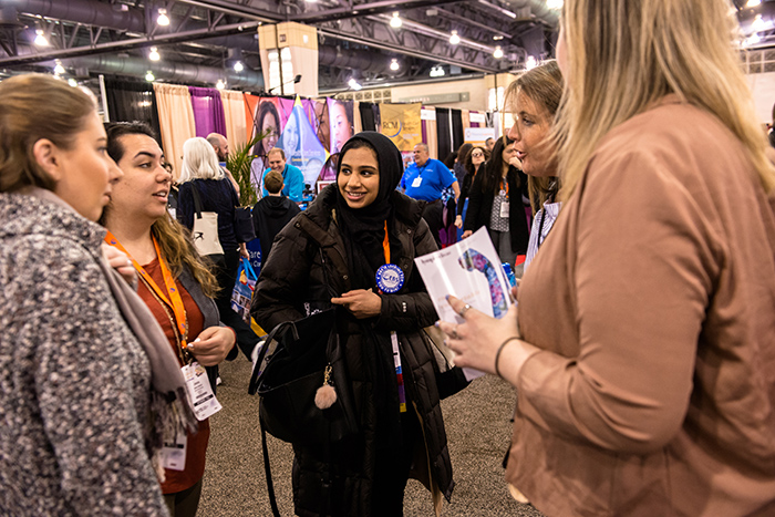 Group of women talking inside crowded AOTA Expo Hall