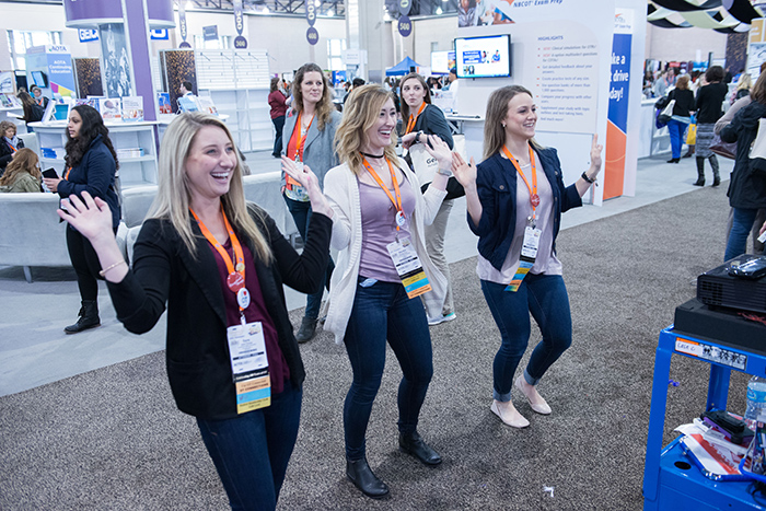Women dancing and smiling at AOTA Annual Conference and Expo hall
