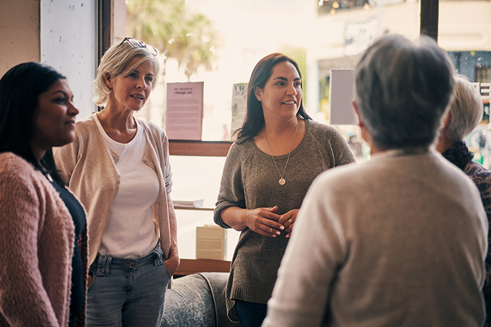 Group of diverse women talking in front of window