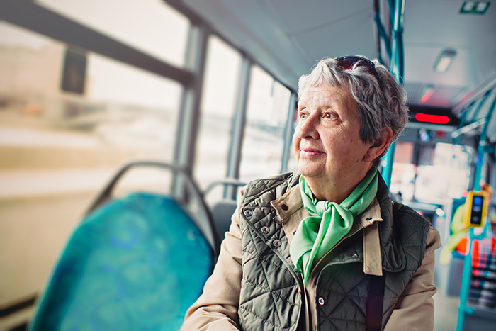 Senior woman riding public bus looking out the window