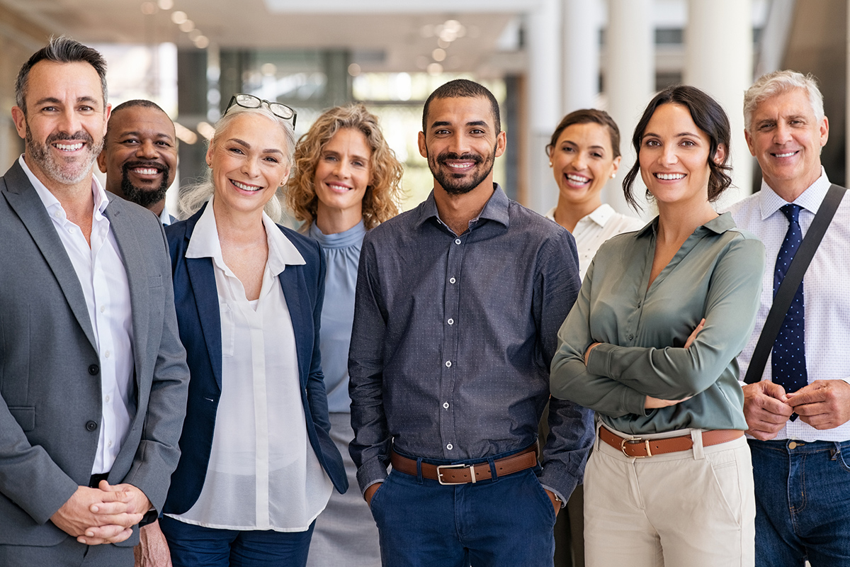 Large diverse group of coworkers smiling at camera inside an office