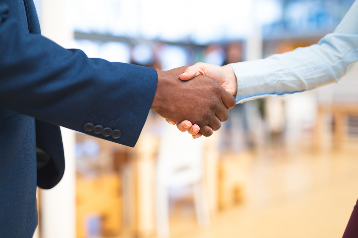 A male and and a female hand shaking in professional clothes
